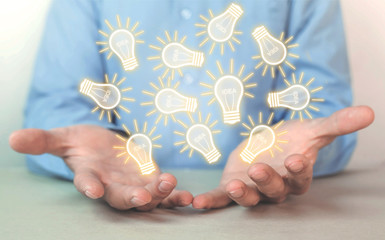 Businessman holding light bulbs. Concept of new idea