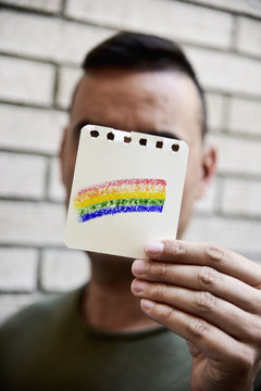 man with a rainbow flag in a piece of paper