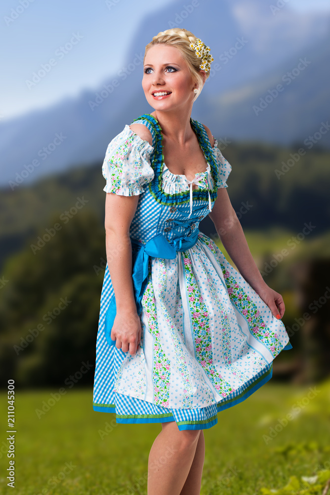 Wall mural junge Frau im Dirndl vor Alpenhintergrund