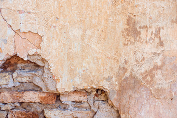 Old Cracked Weathered Shabby Yellow Painted Plastered Peeled Brick Wall Background.