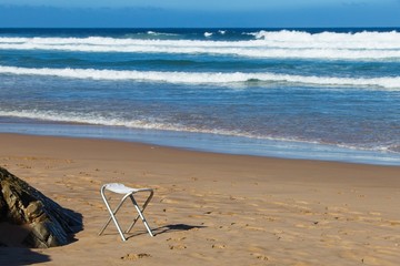 A beach chair on a quiet beach. This image can be used to represent the concept of personal freedom.  
