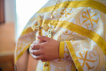 Priest holds golden cross in his hands