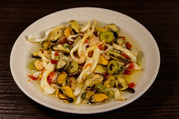 Seafood salad with shrimp, squid and mussels on wooden table