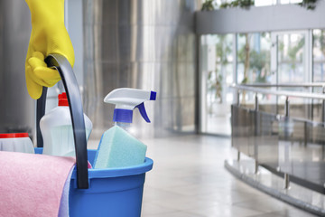 Cleaning lady with a bucket and cleaning products .