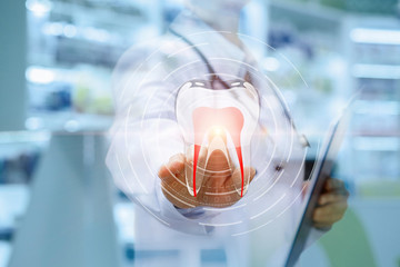 Dentist clicks on the icon of a tooth .