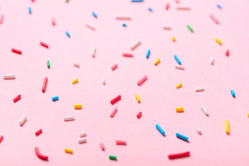 sugar colorful sprinkles over pink background