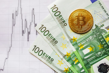 virtual money golden bitcoin on hundred euro bills and on paper forex chart index background.  Exchange bitcoin cash for euro concept