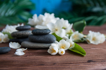Pyramids of gray zen stones with beautiful fresh white flowers and Buddha statue. Concept of harmony, balance and meditation, spa, massage, relax