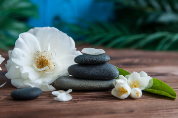 Naklejka na ściany i meble Pyramids of gray zen stones with beautiful fresh white flowers. Concept of harmony, balance and meditation, spa, massage, relax