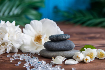 Pyramids of gray zen stones with beautiful fresh white flowers. Concept of harmony, balance and meditation, spa, massage, relax