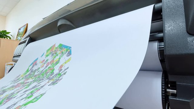 large plotter prints colorful city maps in office