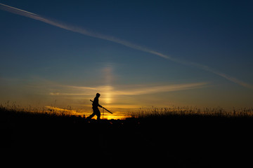 A man with a torch at sunset. Fire show and a lot of the bright sparks in the night