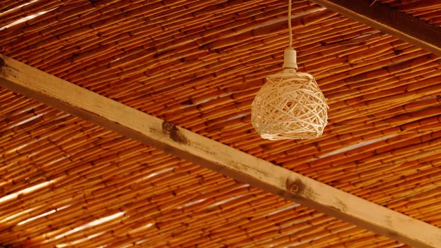 Decorating hanging wicker lantern lamp woven basket and wooden celling in interior outdoor cafe.