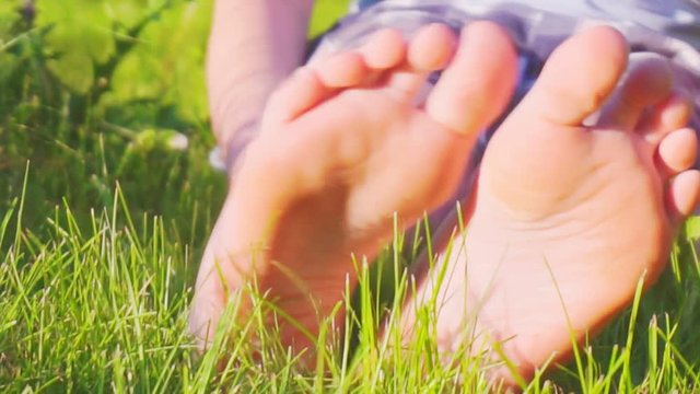 children's bare feet on green grass. close-up