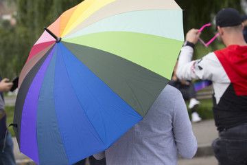 Person with Rainbow Colored umbrella marching at Gay Parade