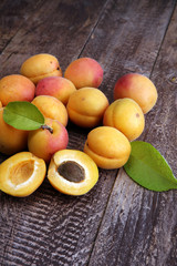 Naklejka na ściany i meble Delicious ripe apricots on wooden table. Fresh cut apricot fruit