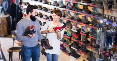 Couple choosing sneakers in store