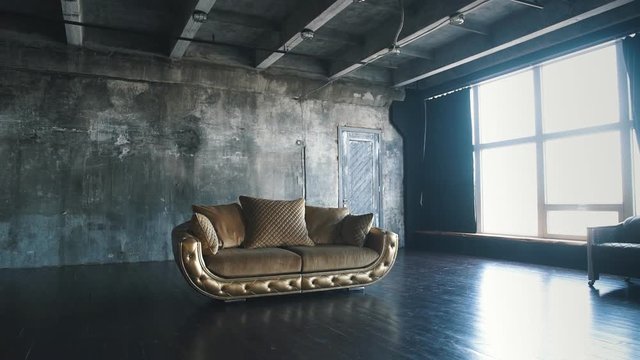 Luxurious sofa in a modern interio. In dark tones and shades of gold