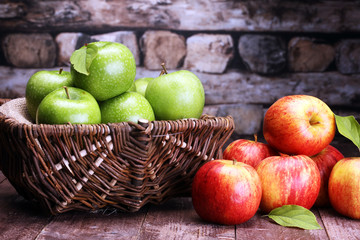 Ripe red apples and green apple on wooden background