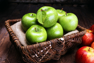 Ripe red apples and green apple on wooden background