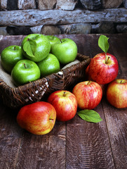 Ripe red apples and green apple on wooden background