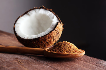 scoop of brown sugar with coconut on wooden background