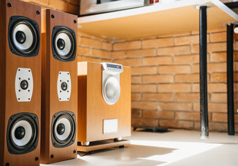 Wooden Music speakers and a subwoofer in the interior of a light room or office. Musical concept.