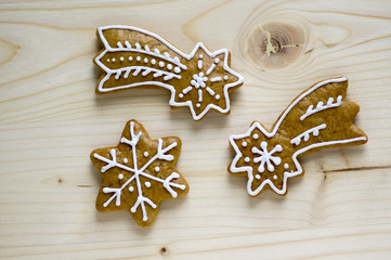 Traditional Czech tasty white painted brown gingerbreads, Christmas comets and stars on wooden table