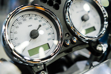 Motorcycle speedometer bord and chrome details close up.