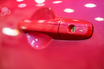 The modern door handle of a red car