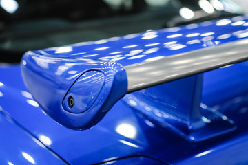 Blue racing spoiler on the car Close-up. The concept of a sports car. - obrazy, fototapety, plakaty