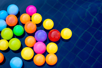 Colorful plastic ball on water in the pool.