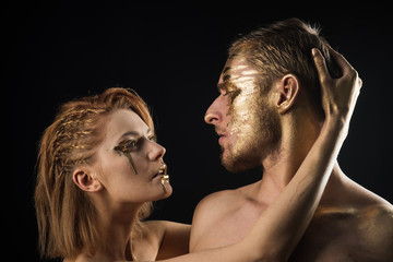 Erotic games of couple in love. Sexy couple with golden body art makeup isolated on black. Golden collagen mask and beauty. 24K Gold. Gold spa and skincare treatment. Man and woman relations