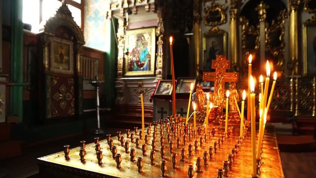 Video shooting of candles on the background of Holy icons in the Church.