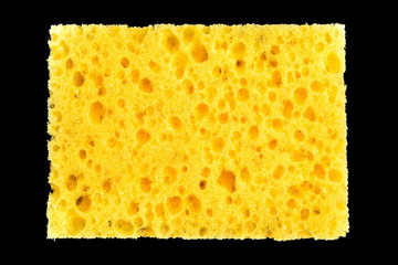 new yellow sponge for washing dishes on black background, abstract background
