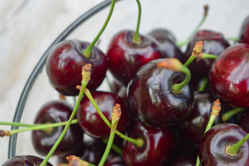 Spelled cherries on the white wooden background