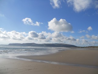 Fototapeta premium Beach with hills and cloud against a blue sky