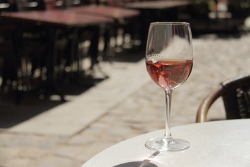 glass of rose wine on the table in street cafe setting 