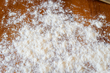 Top side view on white flour on rustic wooden table background, closeup of healthy cooking copyspace surface at home, restaurant, fabric plant