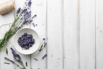 Lavender flowers on white wooden planks background, top view