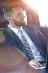 Portrait of a business man in the back seat of a car