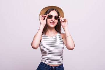 Portrait of a lovely young lady in summer dress and hat posing while standing and laughing isolated over white background