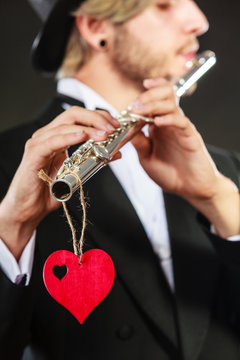 Male flutist with flute and heart. Love melody