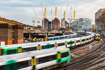Trains on the tracks and power station on background in London