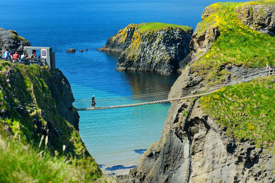Fototapeta Carrick-a-Rede Rope Bridge, famous rope bridge near Ballintoy in County Antrim, linking the mainland to the tiny island of Carrickarede