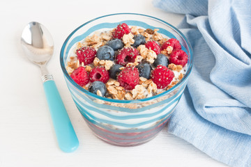 Yogurt with granola and berries / Fresh homemade yogurt with granola, raspberries puree and blueberries for healthy breakfast on white background