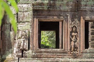 Fototapeta na wymiar Ancient stone ruin of Banteay Kdei temple, Angkor Wat, Cambodia. Ancient temple window to green forest