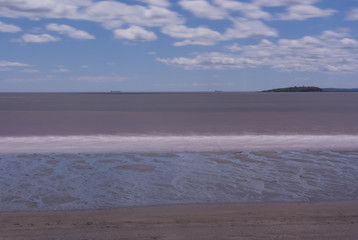 Long Exposure of Tidal Beach with Island and Ships in the Background