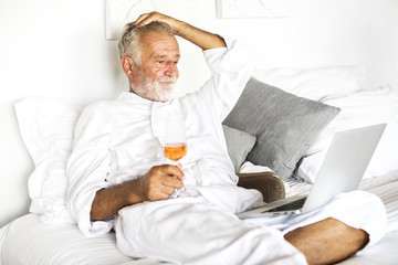 Senior man using laptop in bed