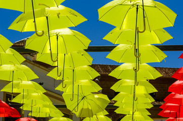 Colourful umbrellas urban street decoration. Hanging colorful umbrellas over blue sky, tourist attraction